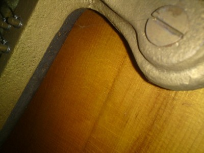 Unlike the perpendicular, even finer cracks in the varnish, the crack in the wood is hardly visible in the photo.